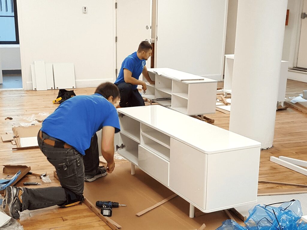 Professional workers assembling furniture in a home or office for efficient and safe setup services