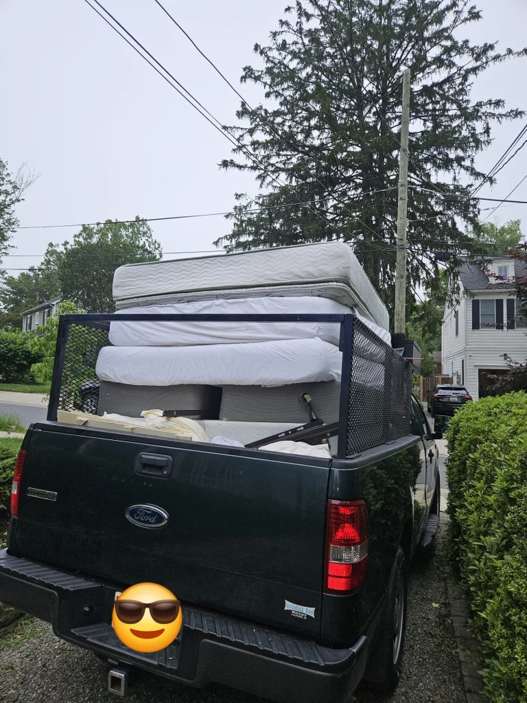 Pickup truck loaded with mattresses and furniture, ready for local delivery or small moving service